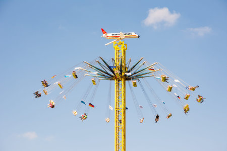 MUNICH, GERMANY - SEPTEMBER 30: People in a high chairoplane on the Oktoberfest in Munich, Germany on September 30, 2015. The Oktoberfest is the biggest beer festival of the world with over 6 million visitors each year. Foto taken from Theresienwiese.のeditorial素材