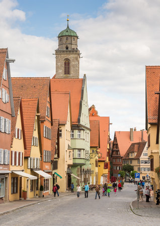 DINKELSBUEHL, GERMANY - SEPTEMBER 27: Tourists in the old town of Dinkelsbuehl, Germany on September 27, 2015. It is one of the best preserved medieaval towns in Germany. Foto taken from Segringer street with view to the minster St. Georg.のeditorial素材