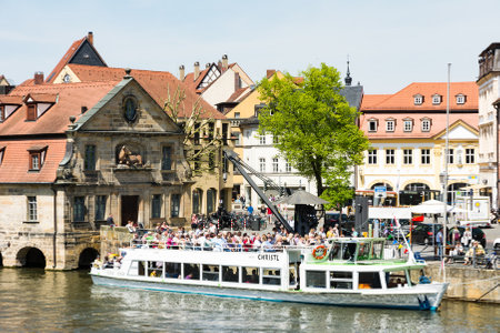 BAMBERG, GERMANY - MAY 6: Tourists on a passenger ship at river Regnitz in Bamberg, Germany on May 6, 2016. Foto taken from Untere  Bruecke with view to Am Kranen.のeditorial素材