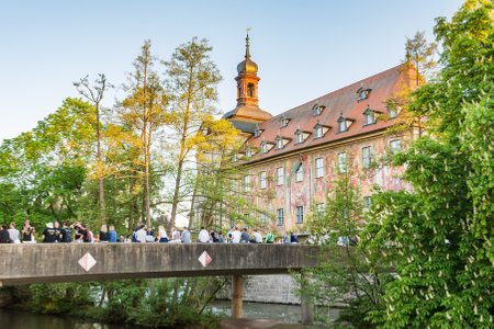 BAMBERG, GERMANY - MAY 7: Tourists at the historic town hall in Bamberg, Germany on May 7, 2016. The famous town hall was built in the 14th century. Foto taken from am Kranen with view to the town hall.のeditorial素材