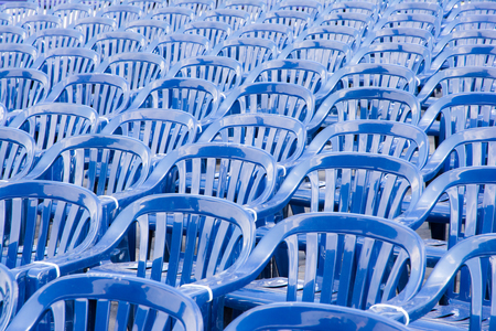 Many rows with a lot of blue pastic chairsの写真素材