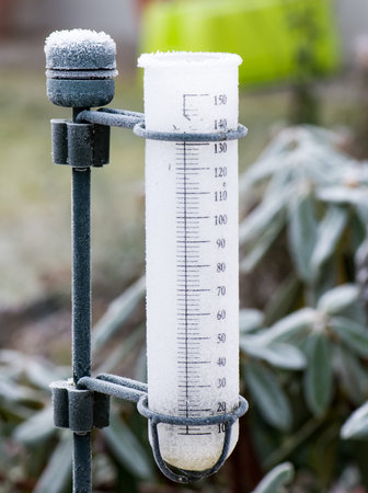 Meteorology with a rain gauge in the garden - frozen after a cold night