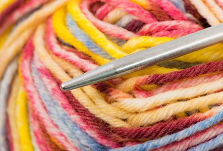 Closeup of knitting needle with multicolored wool