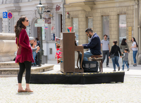 AUGSBURG, GERMANY - MAY 20: Woman listening to an unidentified street musician playing piano in Augsburg, Germany on May 20 ,2017. Foto taken from Maximilianstrasse.のeditorial素材