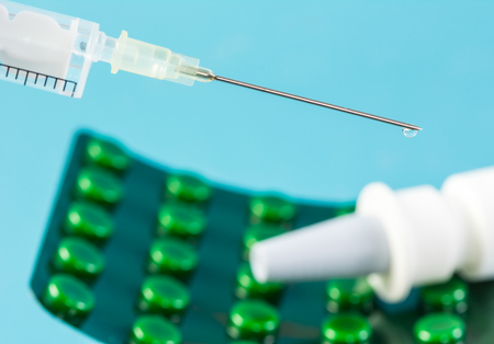 Closeup of a syringe and a blister pack with tabletsの写真素材