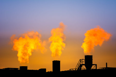 Dark smoke comming from the chimneys of an old factory.