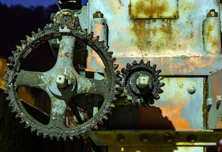 Vintage oily and rusty illuminated cogwheel at nightの写真素材