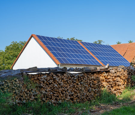 Green energy with solar collectors on the roof of an agricultural buildingの写真素材
