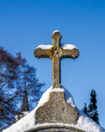 Snow covered historic crucifix in a cemetryの写真素材
