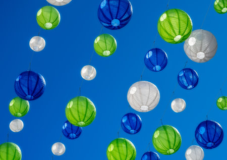 Party with colourful lampions hanging under a blue skyの写真素材