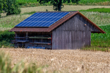 Green energy with solar collectors on the roof of an agricultural buildingの写真素材