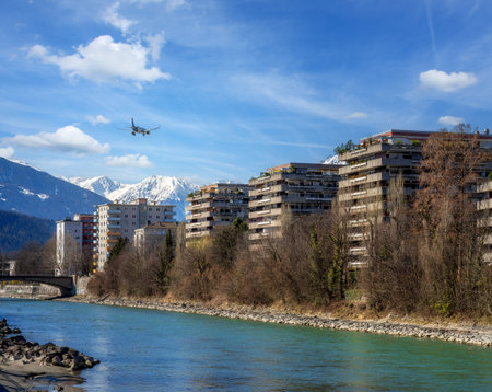 Plane flying over Innsbruck city approaching the airportの写真素材