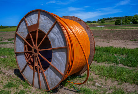 Construction site with a fiber optic cable roll for digital broadband internet communication.