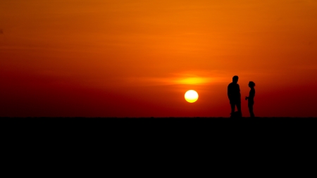 Loving couple enjoying sunset on a sandy beachの写真素材