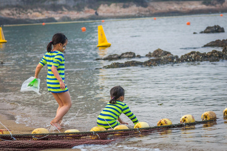 Unidentified children playing on the beach in Park Island  It was mainly developed by Sun Hung Kai Properties as part of the Ma Wan Development joint venture projectのeditorial素材