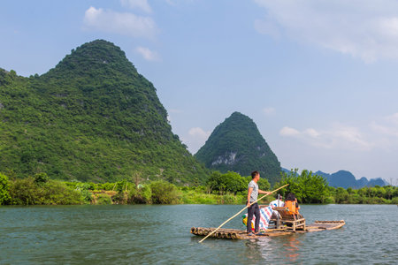 Bamboo rafting in the Yulong River surrounded by dramatic landscape of limestone karst.のeditorial素材