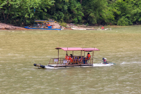 Modern version of traditional bamboo rafts moving in Li river through the dramatic landscape of...