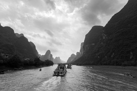 Cruise ship packed with tourists travels the magnificent scenic route along the Li river from Guilin to Yangshou.のeditorial素材