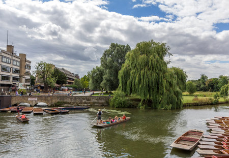 Punting in summer on the river Cam in Cambridge, England. DoubleTree hotel by Hilton can be seen in the background.のeditorial素材