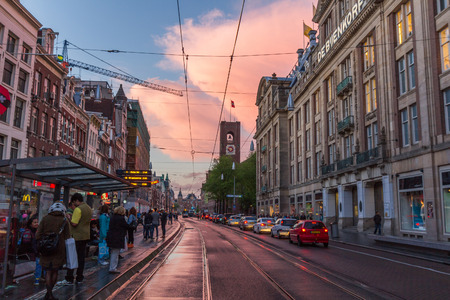 People waiting for a tram at the Damrak. It is running between Amsterdam Centraal in the north and Dam Square in the south.のeditorial素材