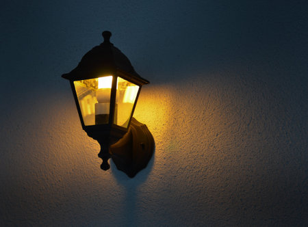 Low angle view of illuminated vintage lamp mounted on wall
