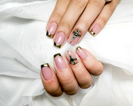 Gold french gel manicure with green  semiprecious stones.の写真素材