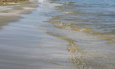 Close-up of sea shore edge and sand  with clear water waves .の写真素材