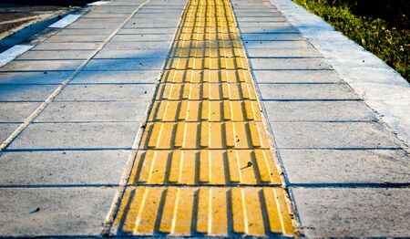 Yellow sidewalk markers for the blind pedestrians .の写真素材