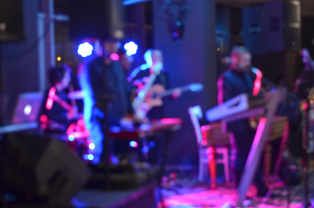 Multicolored light blurred background  of  music band singing  on a stage at a concert