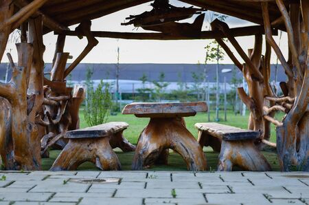 Rustic terrace with table and chairs made of natural wood parts in backyard .の写真素材