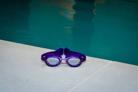 Close-up of  wet blue swim goggles  . Indoor  pool .の写真素材