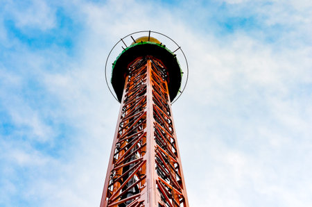 Close-up   view of vertical  iron drop tower or big drop in a amusement  park against  blue sky .  