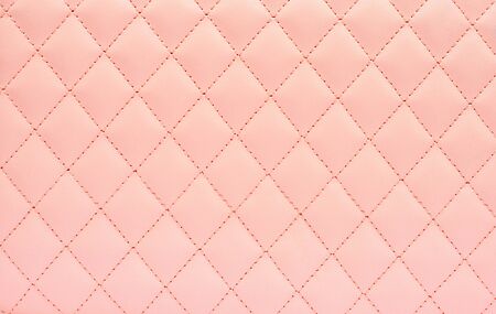 Natural leather background colored in pink and sewn in the form of rhombus. Top view, copy space .の写真素材