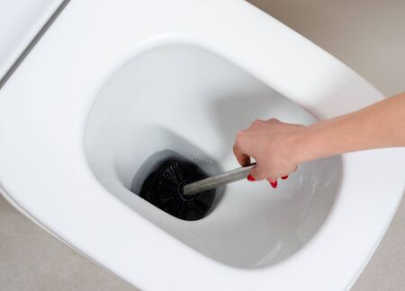 Woman cleaning the toilet bawl with a brushCleaning the bathroom and toilet  of own house  or  restaurant , hotel  .の写真素材