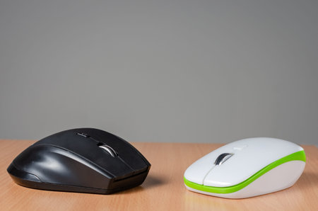 Close view of two wireless- pc mouse devices   on wooden  background.