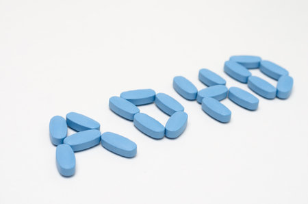 Close- up of ADHD  word written  with  blue pills on white background .の写真素材