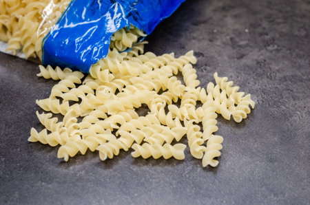Open bag with twisted pasta on the table  ready to cook .の写真素材