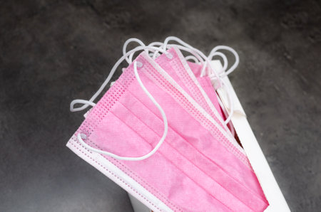 Open box with new pink culaoer surgical masks on the tableの写真素材