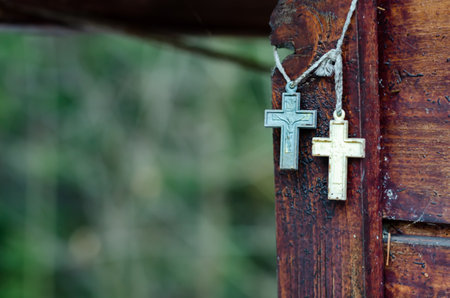 Two Christian crosses hanging near a wooden wall.の写真素材