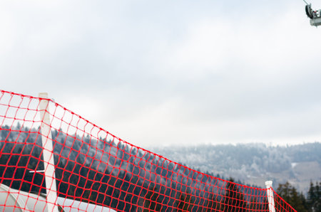 Close-up of  red plastic fence for ski slopes against  mountains.の写真素材