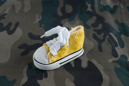 Yellow sneaker on camo fabricの写真素材