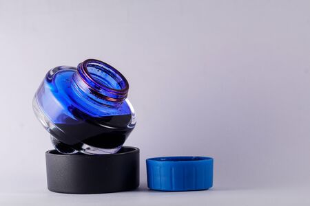 a view of open blue ink bottle against white backgroundの写真素材
