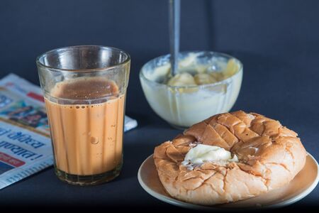 masala chai and bun maska - favorite indian breakfst with tea and bun butter against black backgroundの写真素材