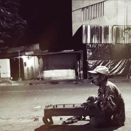 Midnight Street Artist in Solo. He was playing an Indonesia traditional instrument called Kecapi or...