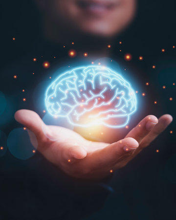 A person's hand cradles a luminous, intricate digital representation of a human brain, surrounded by...