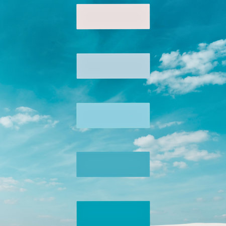 A vertical arrangement of five rectangular blocks in varying shades of blue, superimposed on a soft blue sky with scattered white clouds.の写真素材