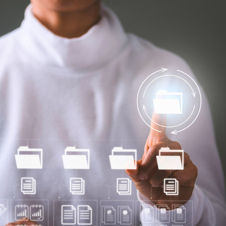 A person's hand touches a glowing virtual interface displaying digital folders and documents, representing data organization and technology.の写真素材