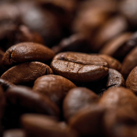 A detailed, blurred background view of dark roasted coffee beans, highlighting their texture and...
