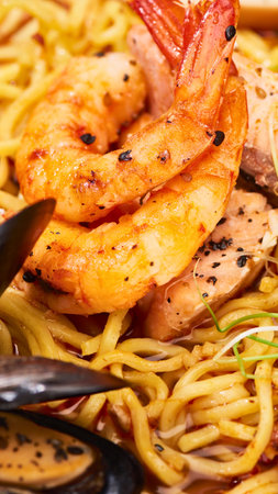 A close-up shot of perfectly cooked shrimp nestled on a bed of savory noodles, ready to be enjoyed.の写真素材