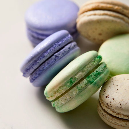 A close-up shot of several pastel-colored French macarons, showcasing their delicate texture and layered filling.の写真素材